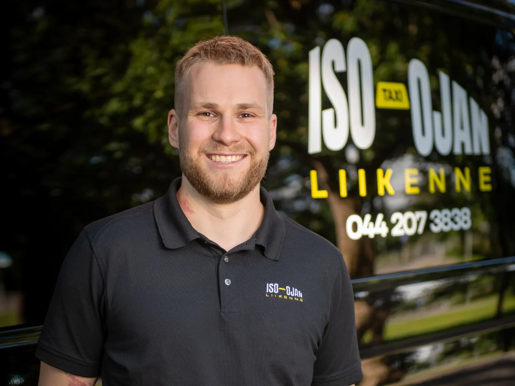 Iso-Ojan Liikenteen yrittäjä Daniel Iso-Oja hymyilee taksin edessä